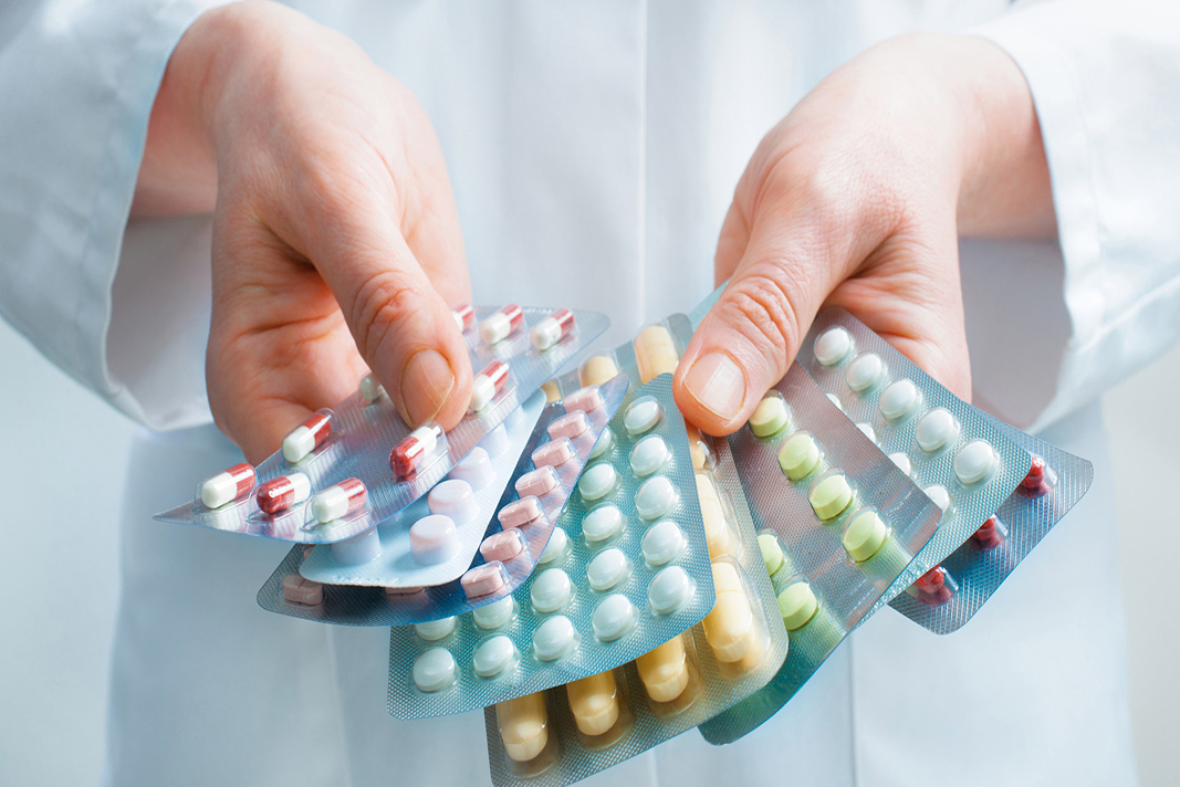 Hand of doctors holding many different pills