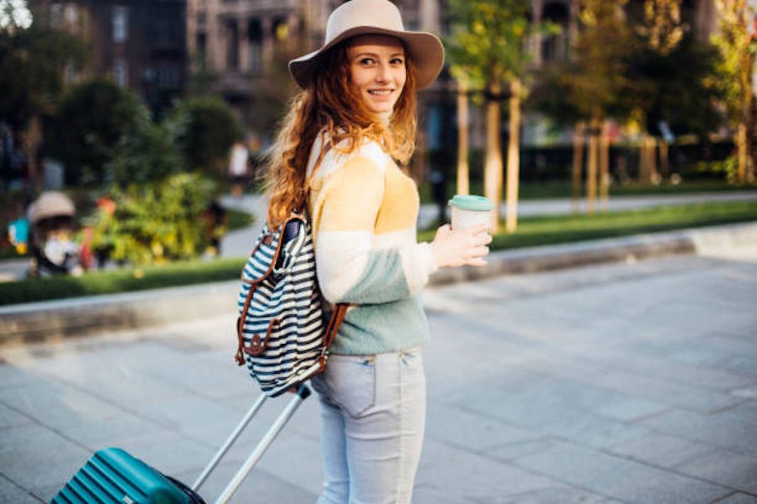 Beautiful, young female tourist drinking coffee and exploring the city.